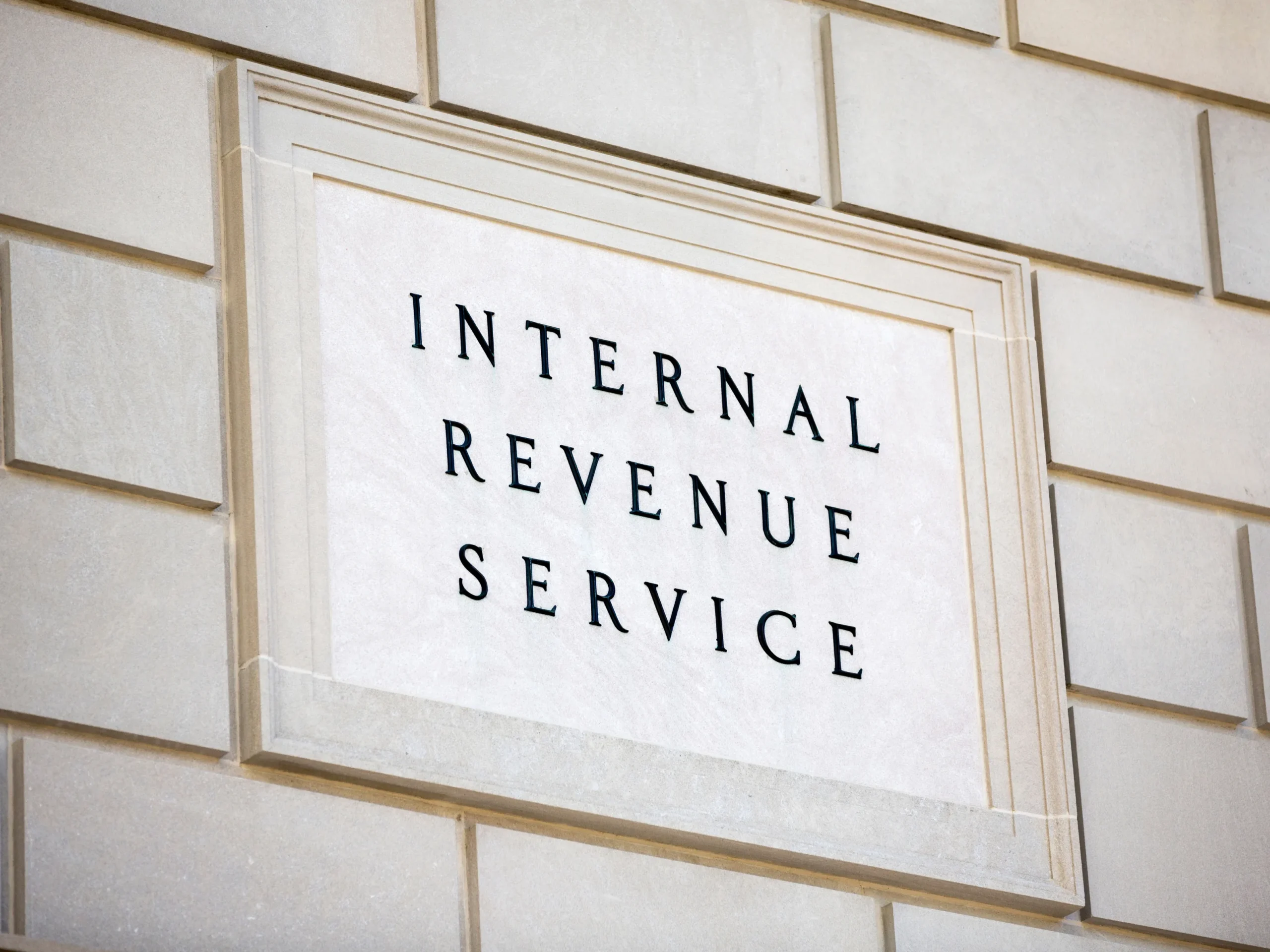 Sign for the IRS saying "internal revenue service" on a brick wall