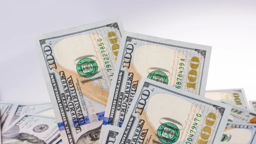 pile of $100 bills sitting with white background