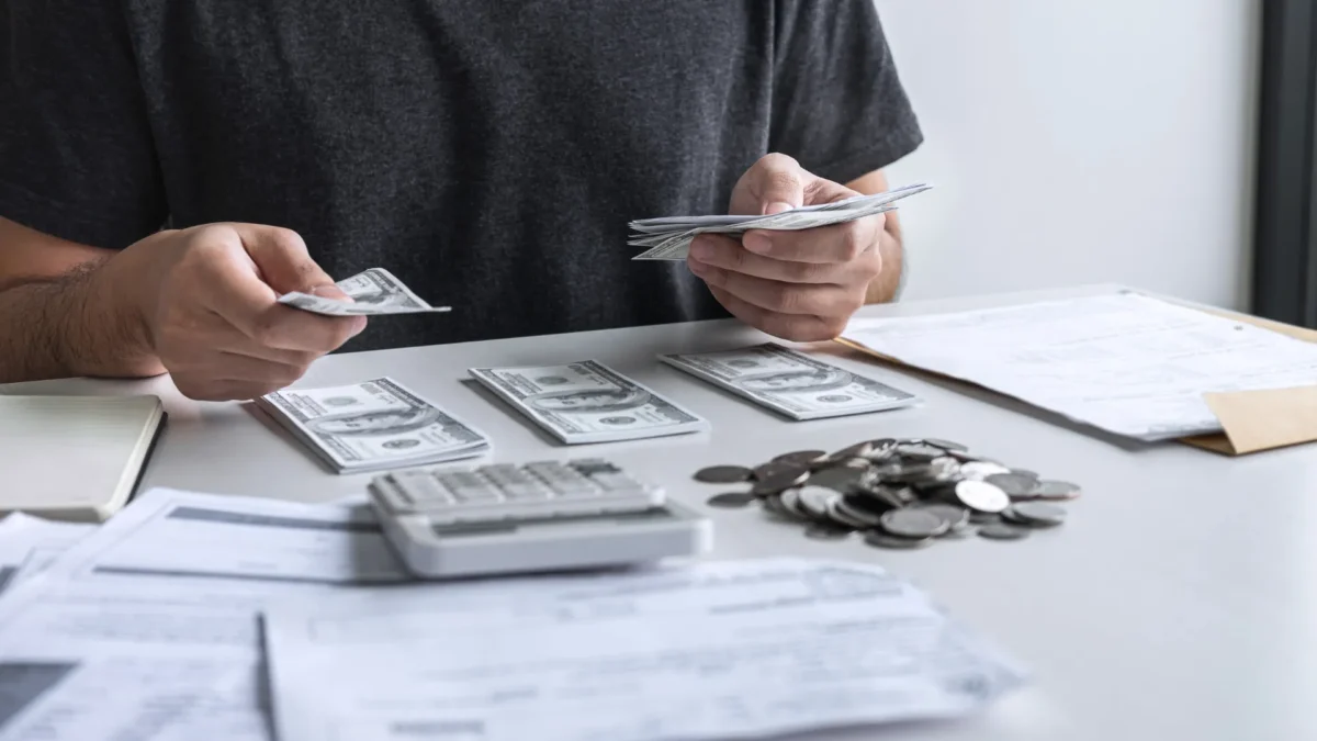 What are Back Taxes? Man sorting out his cash and coins with a calculator