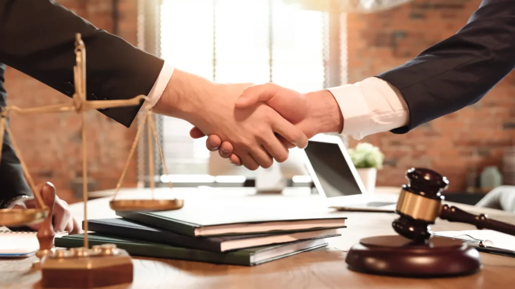 Tax audit outcomes between two men shaking hands over a desk, one being a tax attorney