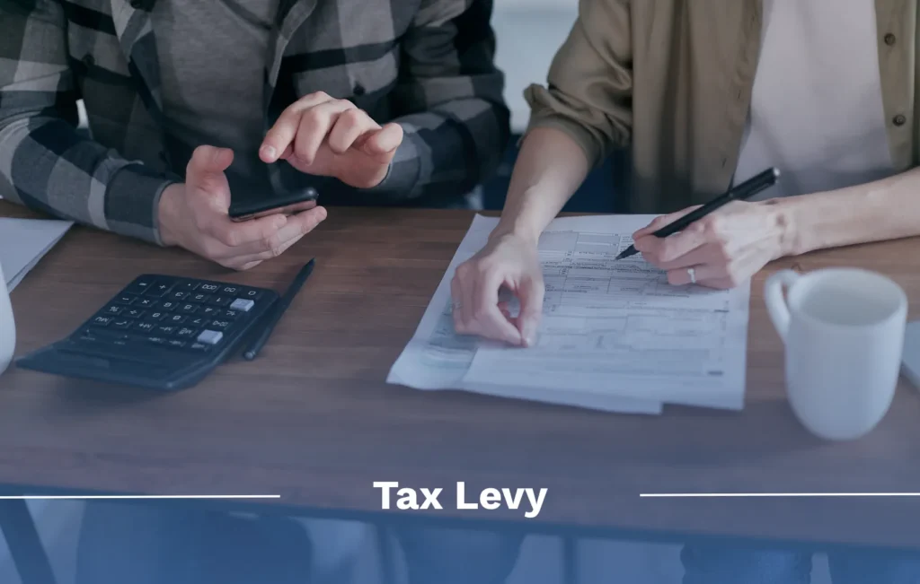 What is a tax levy? 2 people sitting at table with tax documents, a calculator, and mugs
