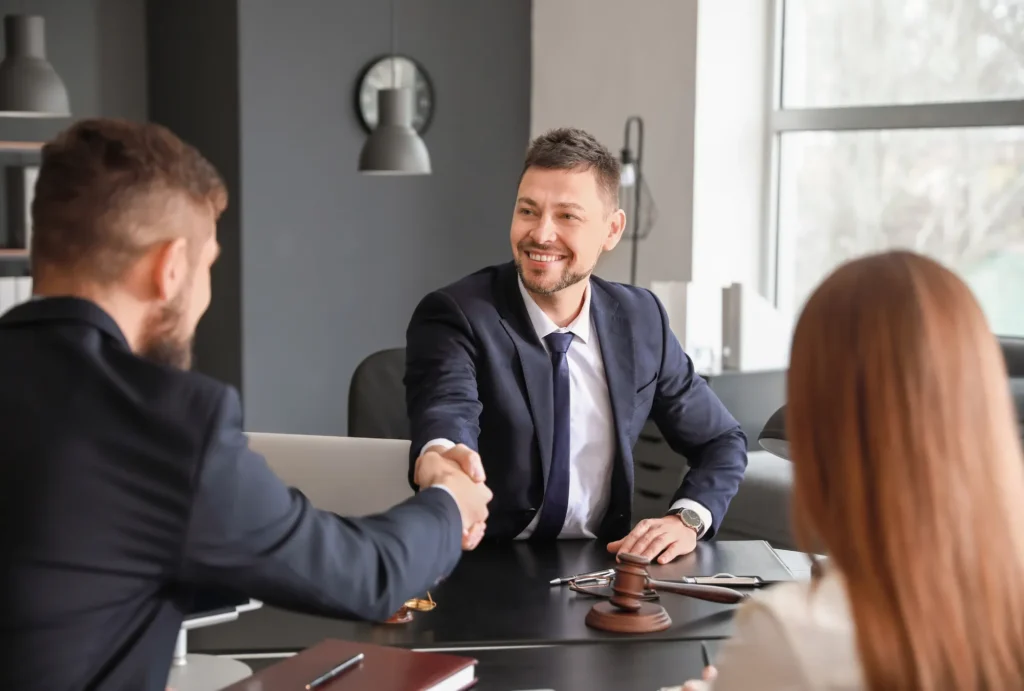 attorney shaking hands with man seated next to woman
